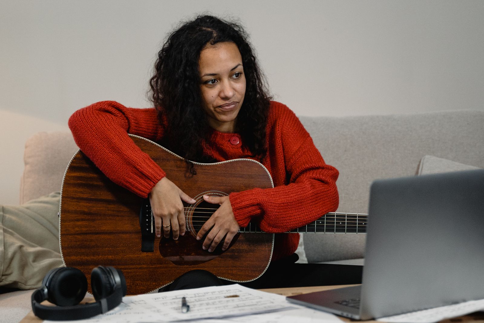 Adult student practicing guitar with sheet music during a lesson
