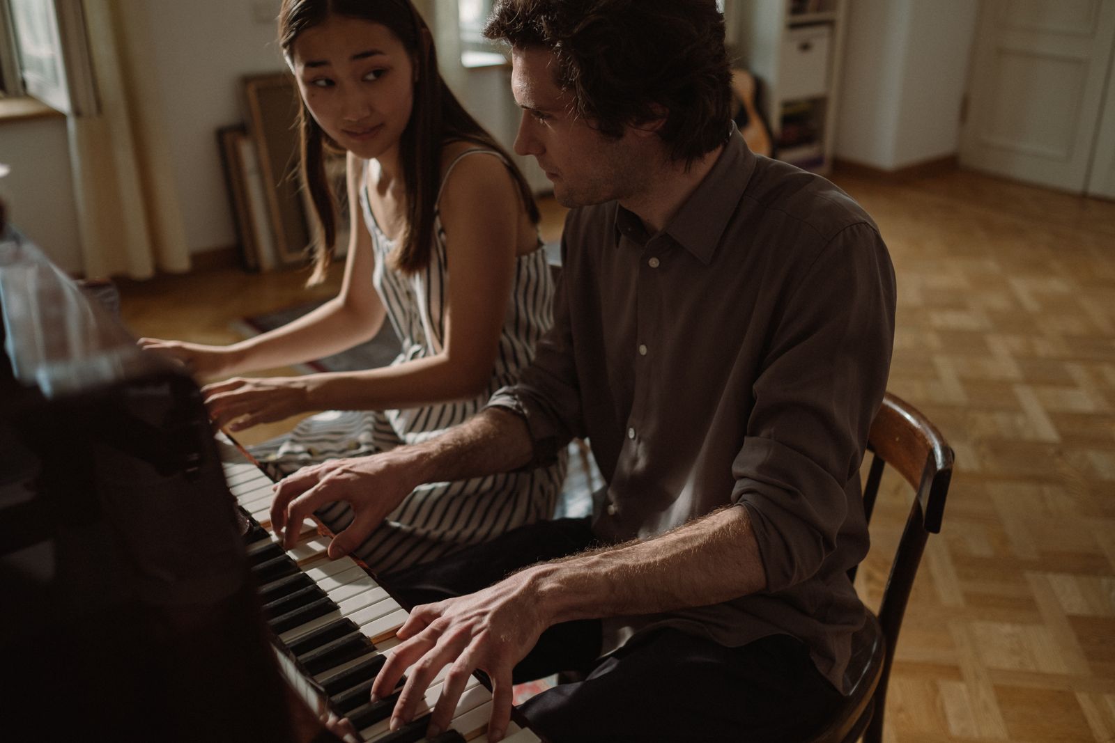 Instructor teaching an adult student during a private piano lesson