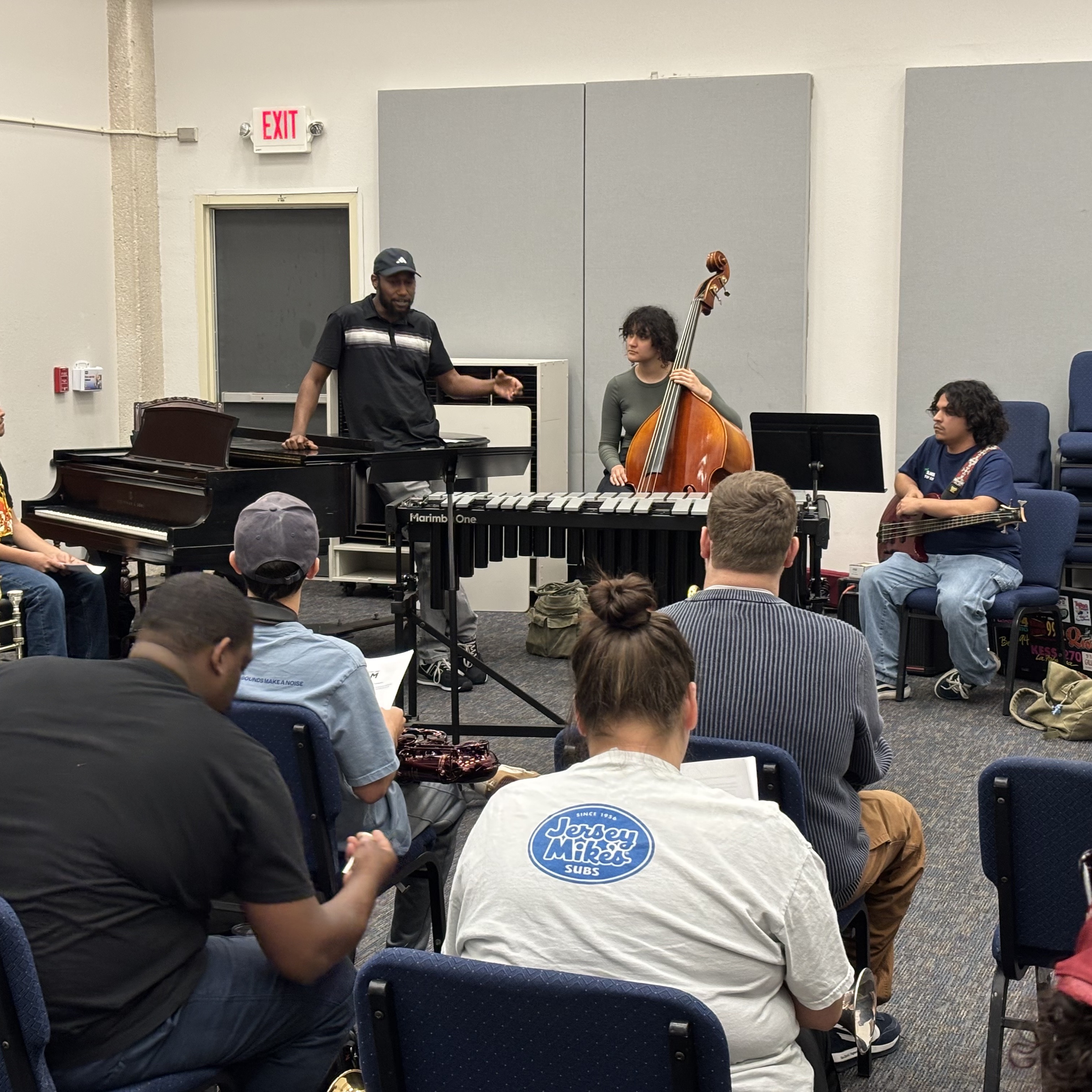 Students in a group music class with piano, marimba, and bass