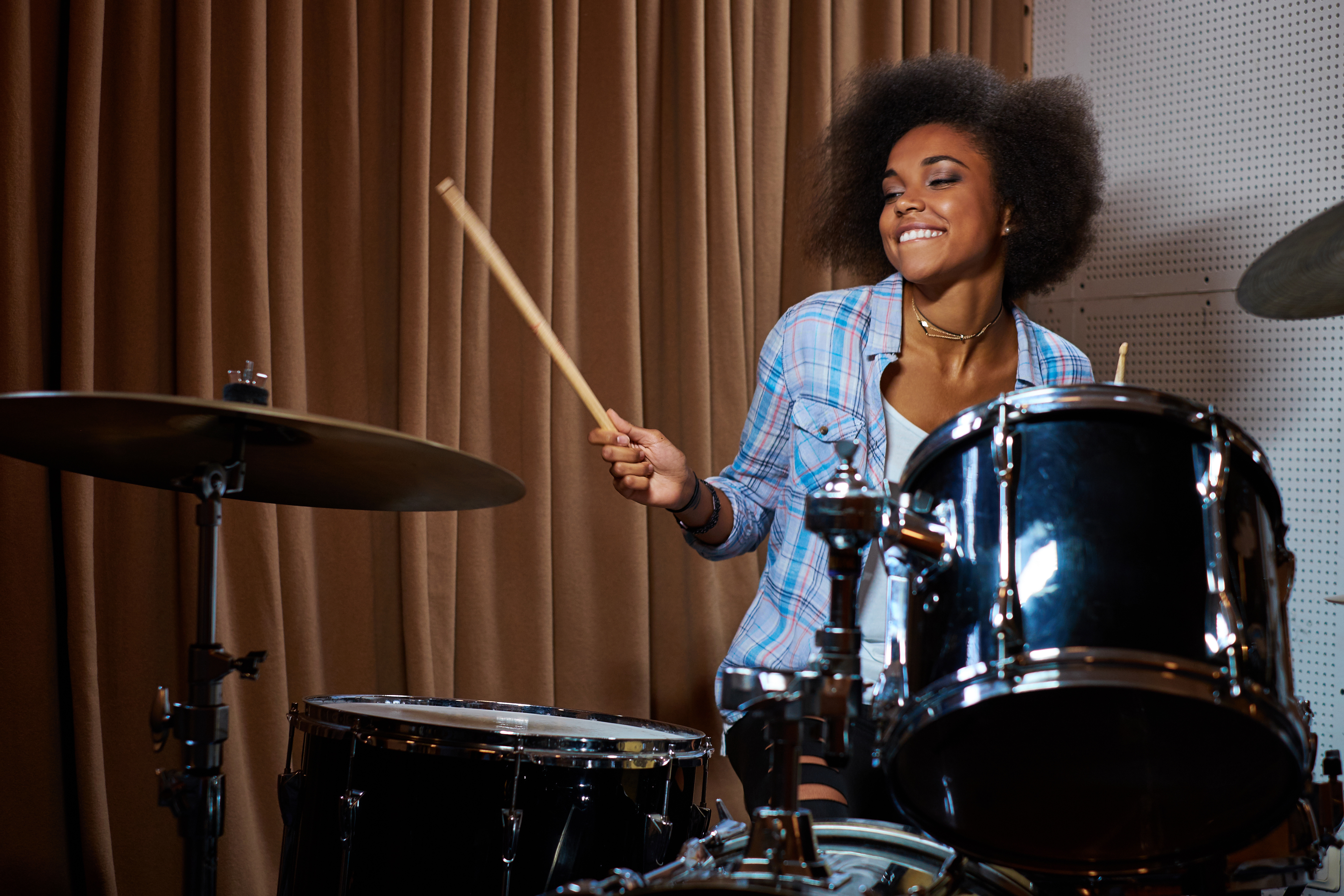 Student playing drums in a music studio