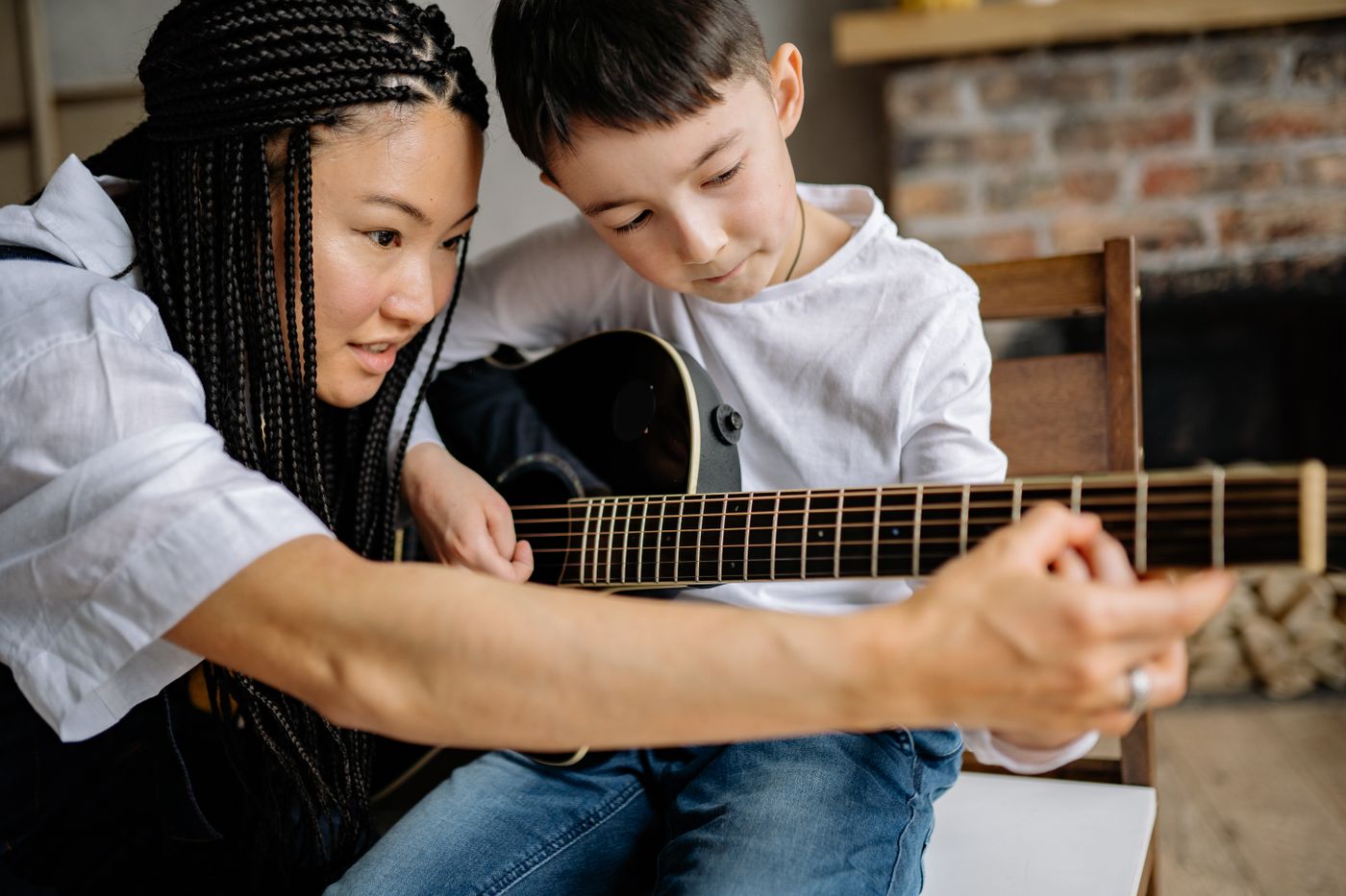 Instructor teaching a youth student during a private guitar lesson