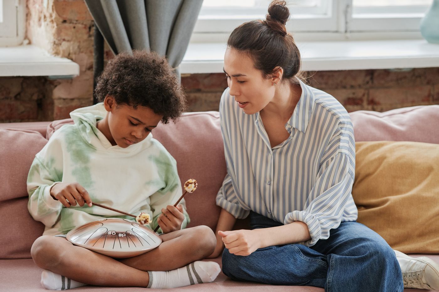 Instructor teaching a student to play a percussion instrument
