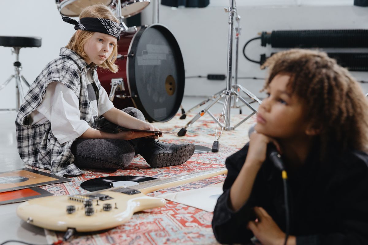 Youth musicians exploring drums and guitar together in a group lesson