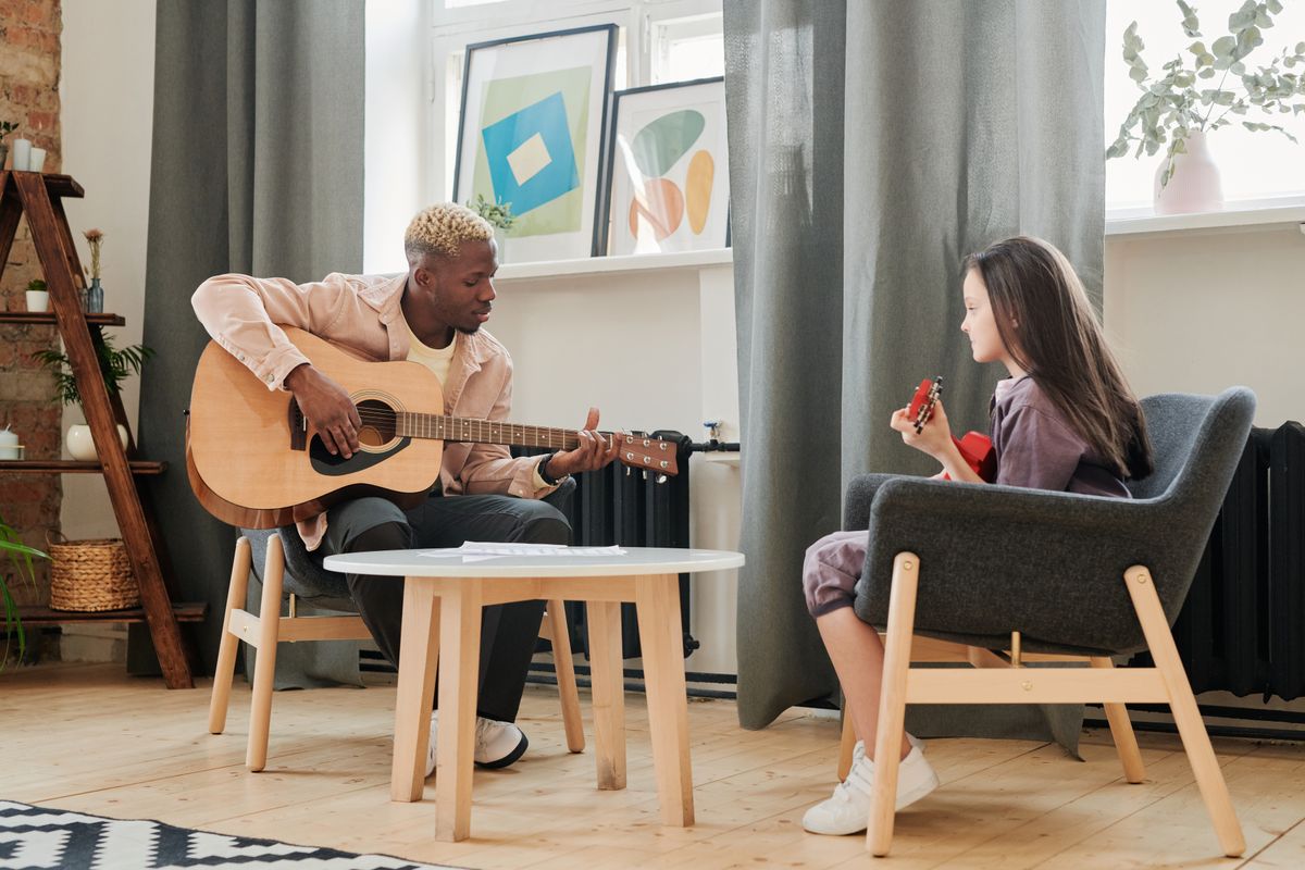 Instructor teaching a youth student during a private guitar lesson