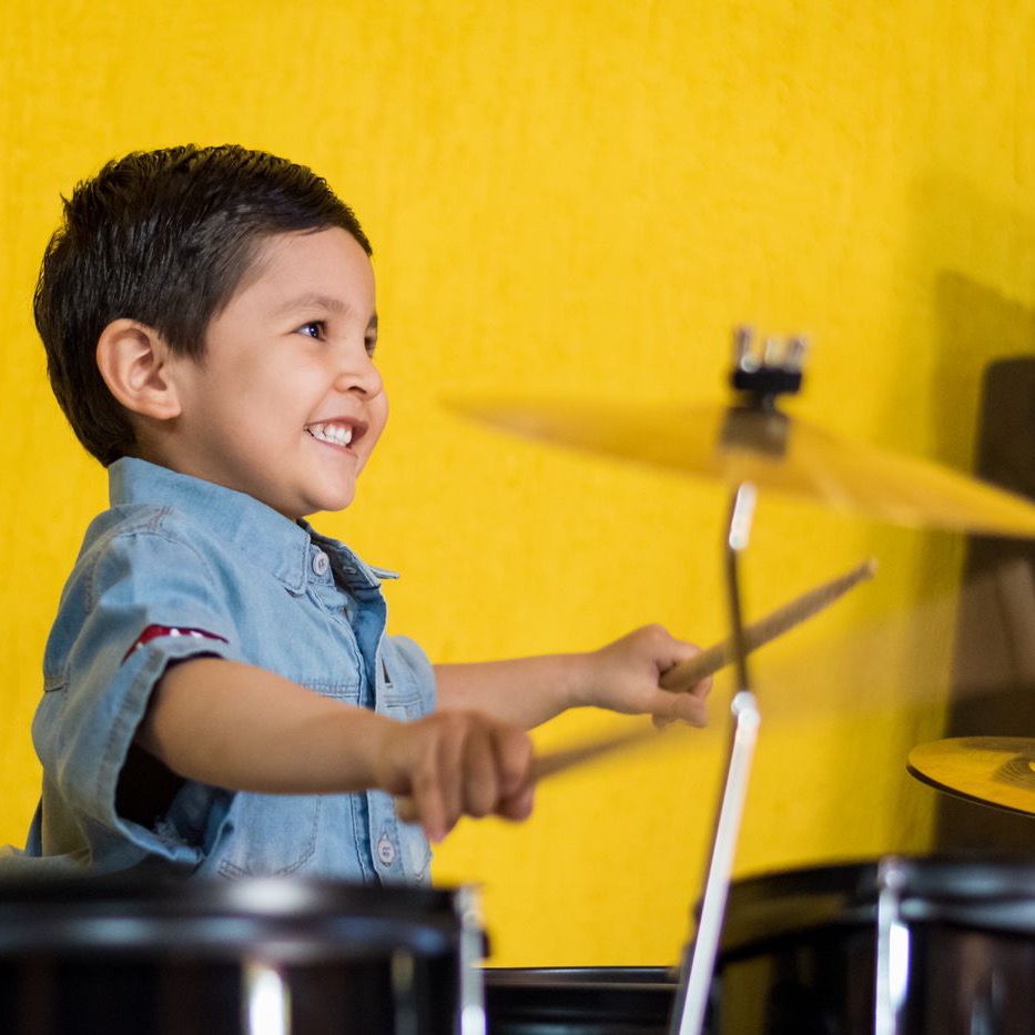 Student playing drums during a music lesson